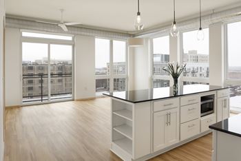 A kitchen with white cabinets and a black countertop.
